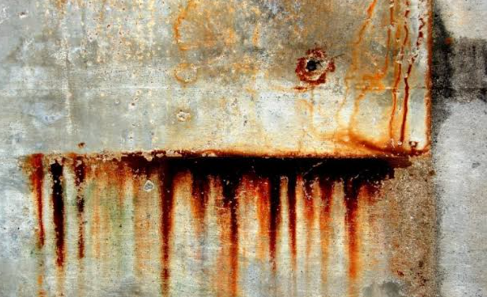 Corrosion and rust streaks on a metal panel