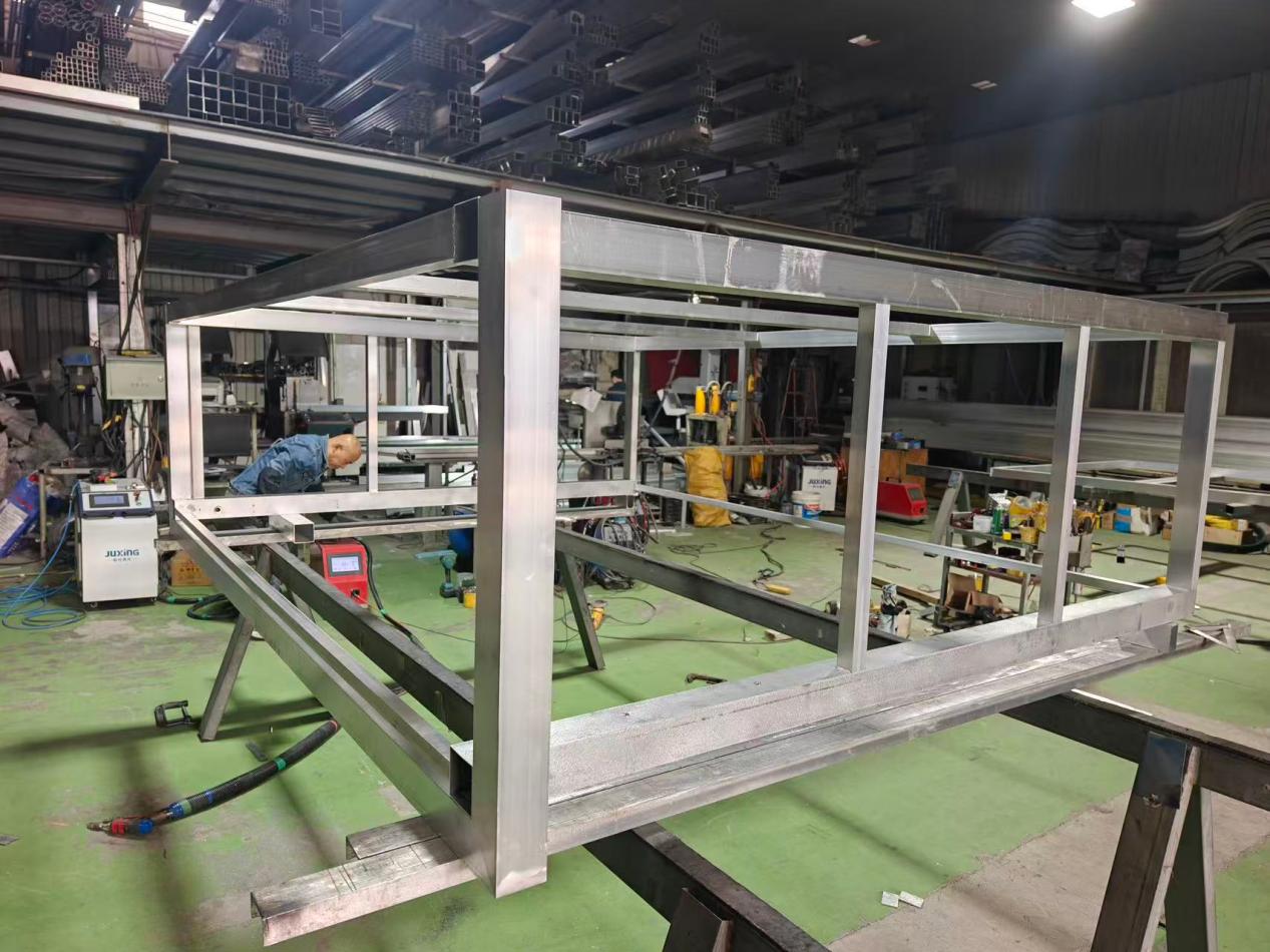 A worker assembling outdoor kitchen structural frames inside the bluehour manufacturing workshop in China