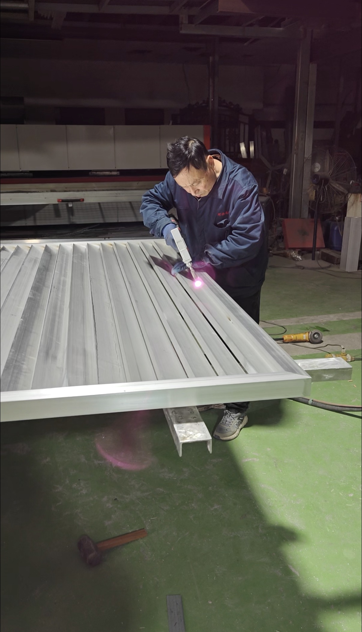 A worker joining an aluminium panel in the Bluehour workshop
